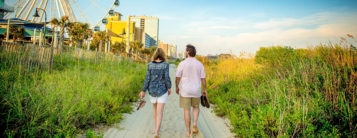 Couple walks amid the dunes near the Myrtle Beach boardwalk