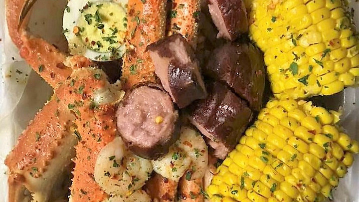 Plate of crab legs, sausage, boiled eggs, corn on the cob from Gullah Gullah Fish